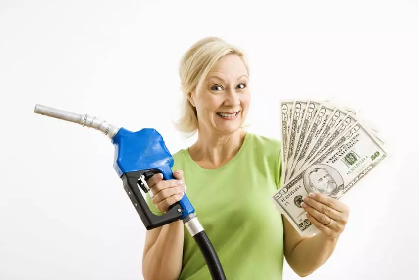 Woman at gas pump holding money