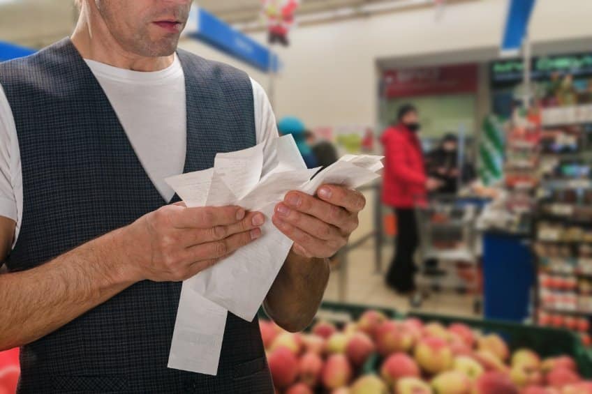man looking at grocery bill